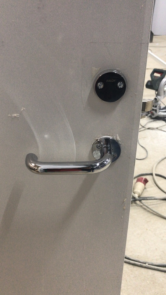 Дверная ручка Abloy установленная на пластиковой двери Aquadoor